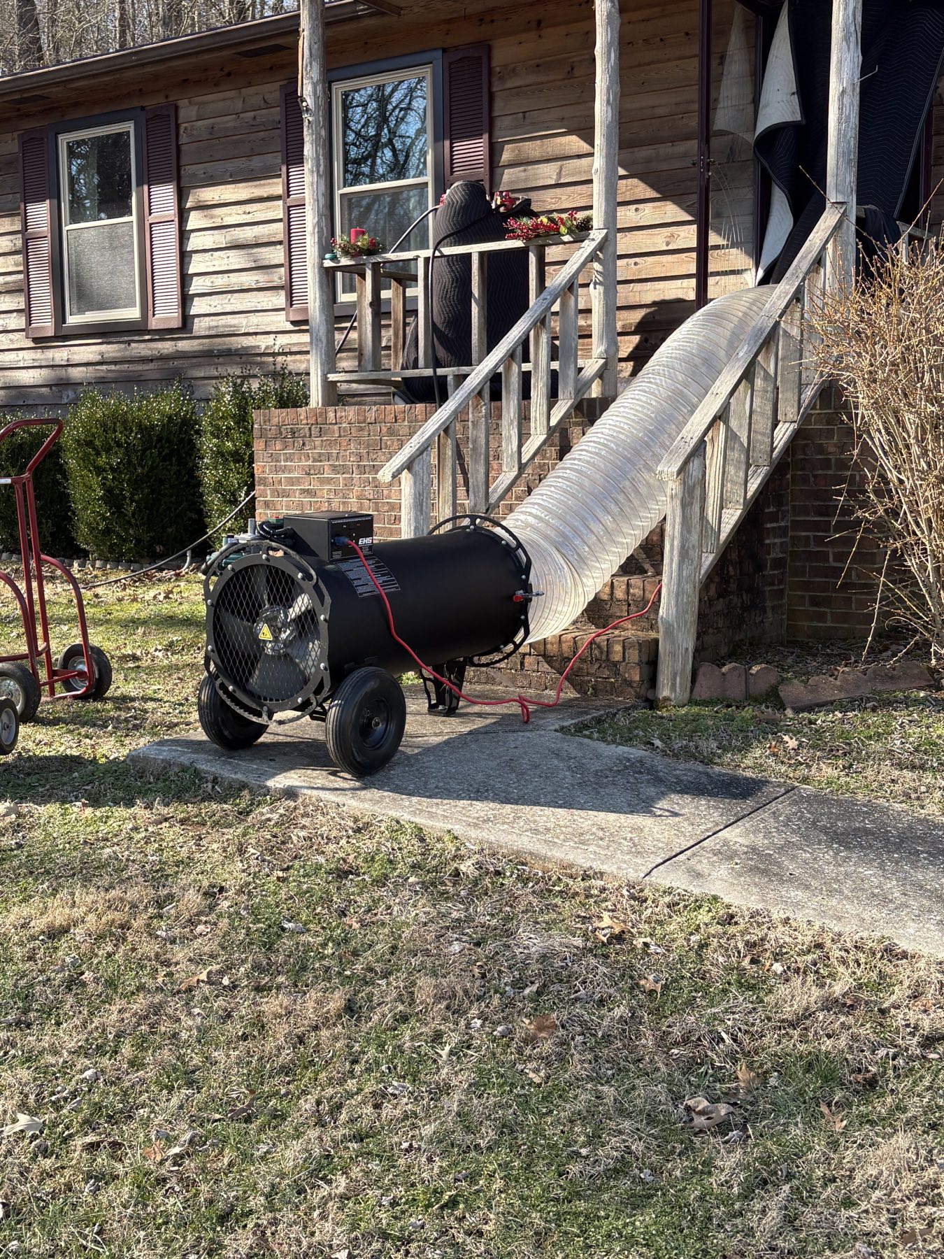 EcoForce heat treatment hose routed up porch steps into a wood-sided home in the Nashville area