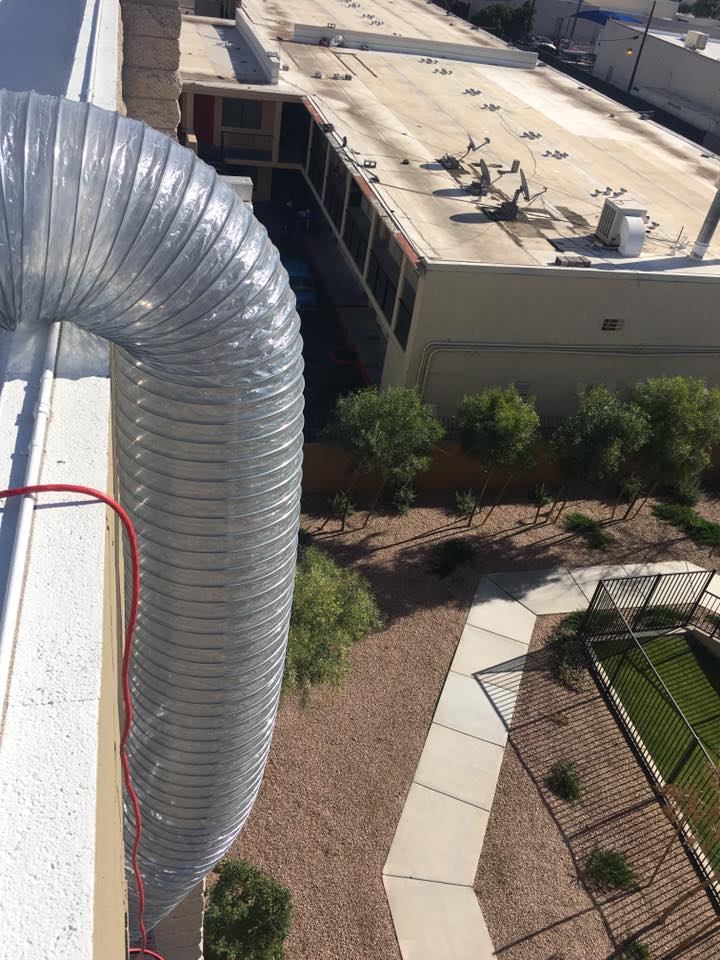 Large EcoForce treatment duct dropping from a rooftop edge toward a courtyard-level treatment area